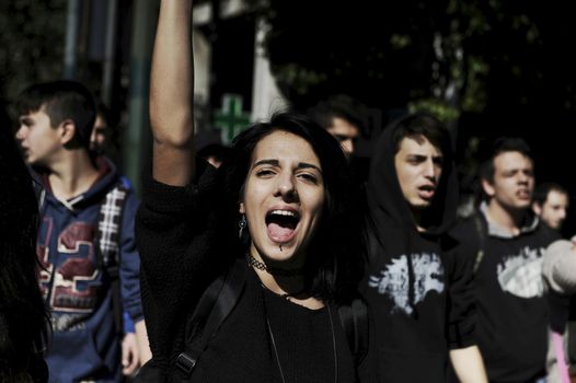 GREECE, Athens: A woman cries out as thousands of student-protesters fill the streets of Athens, Greece on November 2, 2015. The young demonstrators yell chants and carry signs as they rally against cuts to education and a shortage of teachers, amid ongoing protests against austerity in Greece. Reports from local media indicate that a contingent had broken off from the larger protest, vandalizing a cell phone store, and trying to damage a bank on Othonos, a street in Athens.