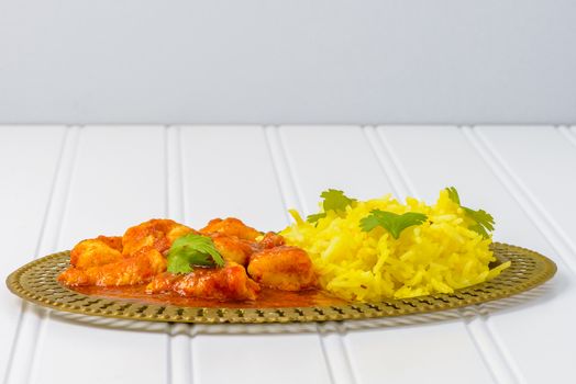 Plate of spicy chicken vindaloo served with basmati rice.