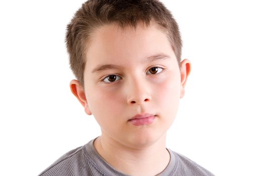 Head and Shoulders Close Up Portrait of Young Boy in Gray T-Shirt Staring at Camera with Blank Expression in Studio with White Background