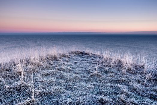 Panoramic view winter sea and frozen grass