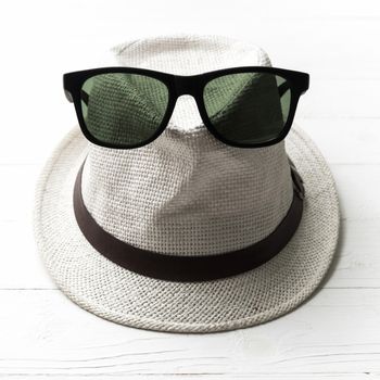 hat and sunglasses on white table