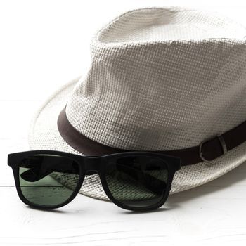 hat and sunglasses on white table