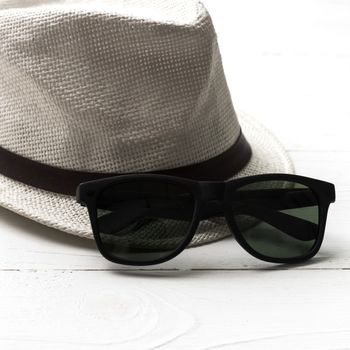 hat and sunglasses on white table