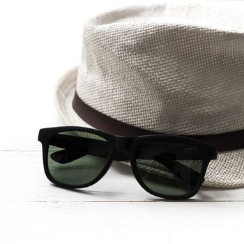 hat and sunglasses on white table