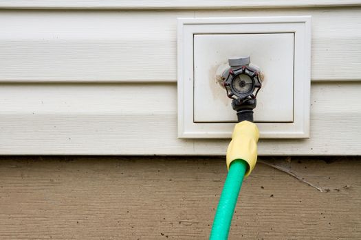 Spigot attached to a house letting water flow