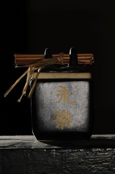 Abstract zen style tea container isolated on black with japanese letters