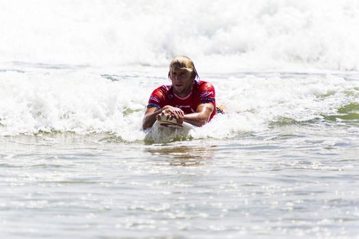 SNAPPER ROCKS, GOLD COAST, AUSTRALIA - 9 MARCH: Unidentified Surfer races the Quiksilver & Roxy Pro World Title Event. 9 March 2013, Snapper Rocks, Gold Coast, Australia