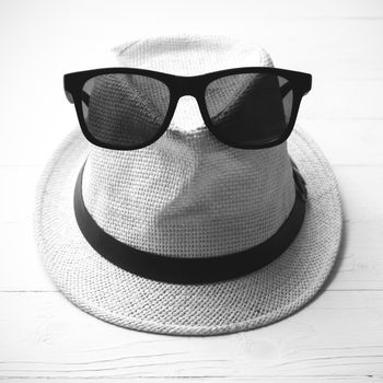 hat and sunglasses on white table black and white color