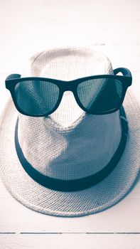 hat and sunglasses on white table vintage style