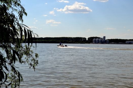 Friends came by boat to ride on the river waters. The clouds in the sky and they run.