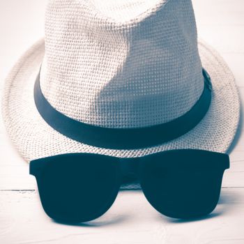 hat and sunglasses on white table vintage style