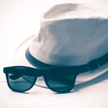 hat and sunglasses on white table vintage style