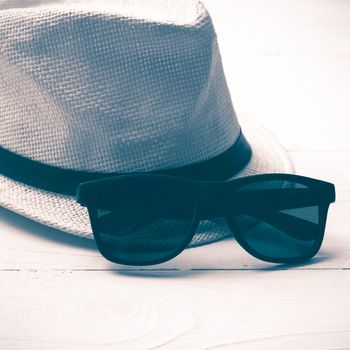 hat and sunglasses on white table vintage style