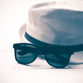 hat and sunglasses on white table vintage style