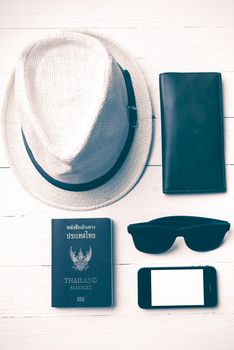 hat sunglasses smart phone and passport over white table vintage style