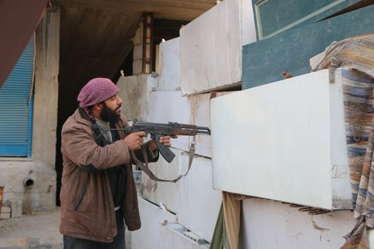 SYRIA, Harasta : A rebel checks enemy presence through a hand-made barricade while clashes between several rebel factions, Syrian army and its allies intensify in Harasta, in the northern suburb of the Syrian capital Damascus, on November 2, 2015. Violence in Damascus suburbs where rebels have been entrenched for years has claimed the lives of thousands of civilians.