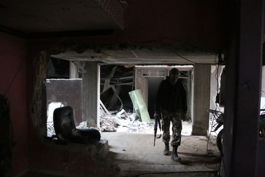 SYRIA, Harasta : A rebel goes in a destroyed building while clashes between several rebel factions, Syrian army and its allies intensify in Harasta, in the northern suburb of the Syrian capital Damascus, on November 2, 2015. Violence in Damascus suburbs where rebels have been entrenched for years has claimed the lives of thousands of civilians.
