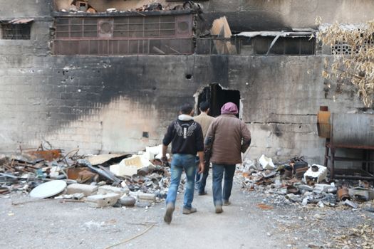 SYRIA, Harasta : Rebels enter a destroyed building while clashes between several rebel factions, Syrian army and its allies intensify in Harasta, in the northern suburb of the Syrian capital Damascus, on November 2, 2015. Violence in Damascus suburbs where rebels have been entrenched for years has claimed the lives of thousands of civilians.