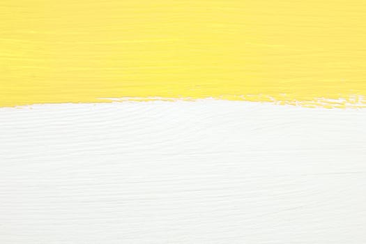 Horizontal stripe of yellow paint over white painted wooden background