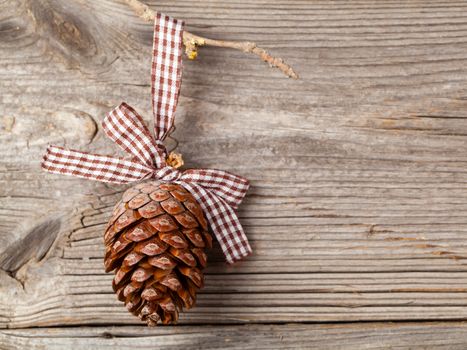 Cedar cones with branch on wood background, with free space for your text