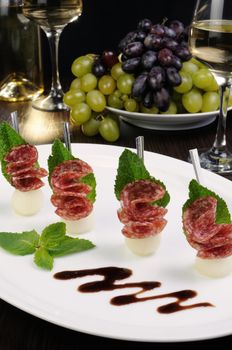 Canape of balls a melon and salami with mint