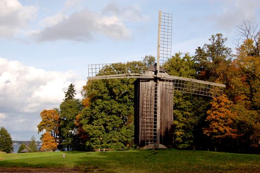 Old wooden windmill in the park at autumn