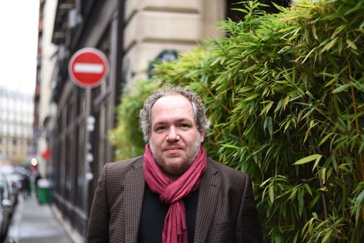 FRANCE, Paris : French author Mathias Enard poses with his book Boussole (Compass) outside the Drouant restaurant in Paris after he was awarded with France's top literary prize, the Prix Goncourt, on November 3, 2015.