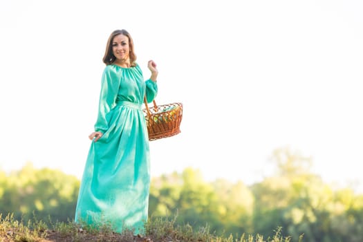 Young beautiful girl in a long dress walking in the woods on a warm summer day