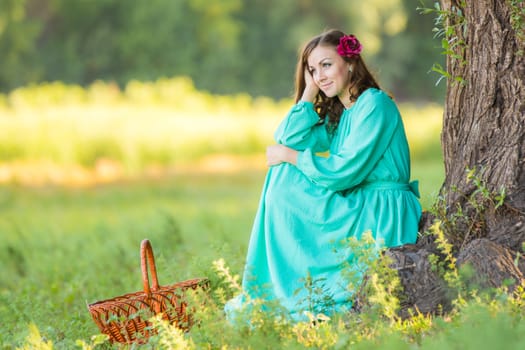 The young beautiful girl walks through the forest on a warm summer day
