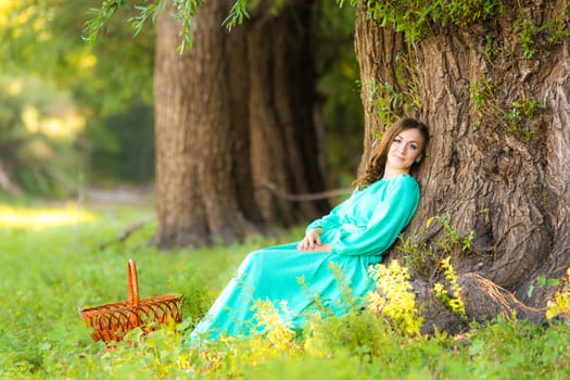 The young beautiful girl walks through the forest on a warm summer day