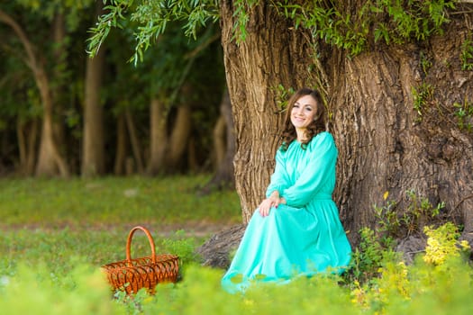 The young beautiful girl walks through the forest on a warm summer day