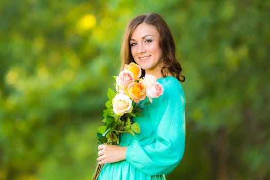 Young beautiful girl in a long dress walking in the woods on a warm summer day