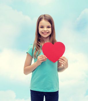 love, happiness and people concept - smiling little girl with red heart