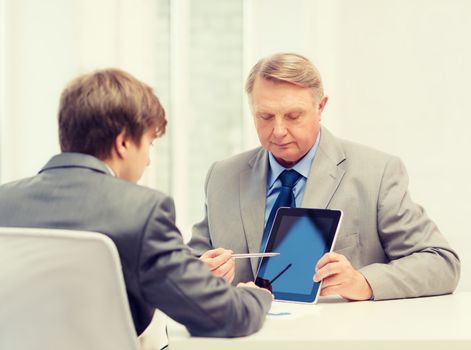 business, advertisement, technology and office concept - older man and young man with tablet pc computer in office