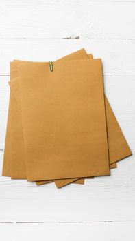 brown paper with green paper clip over white table