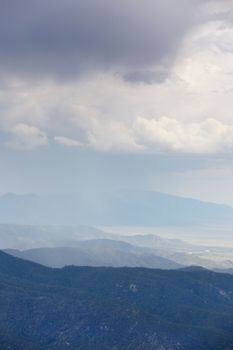 Waves of mountains, valley, and clouds are scenic view from Sandia Peak on a summer day.  Spectacular view in Sandia Mountains from summit.  