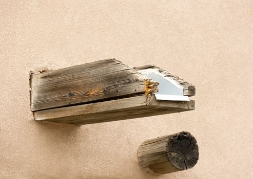 Wood water spout and viga, both old, on adobe wall of Southwestern style building in Old Town district of Albuquerque, New Mexico