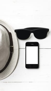 hat sunglasses and smart phone on white table