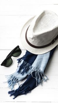 hat and blue with sunglasses scarf on white table