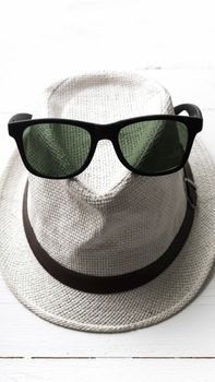 hat and sunglasses on white table