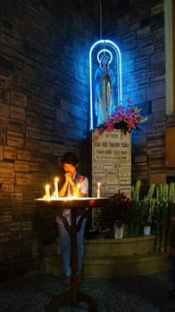 HO CHI MINH CITY, VIET NAM- OCT 12: Asian people pray at Notre Dame cathedral, a famous place for travel, church with statue, symbol of christian, Vietnam, Oct 12, 2014