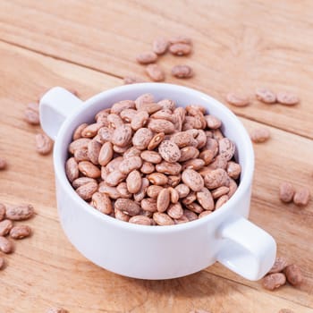 Brown pinto beans in the bowl and brown pinto beans  background.