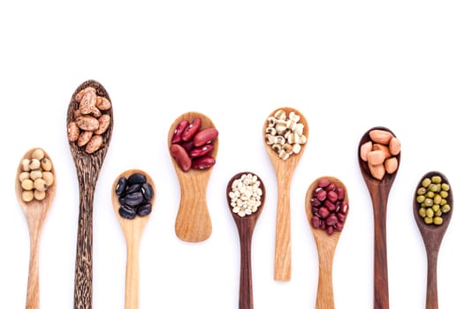 Assortment of beans and lentils in wooden spoon isolate on white  background. mung bean, groundnut, soybean, red kidney bean , black bean ,red bean and brown pinto beans .