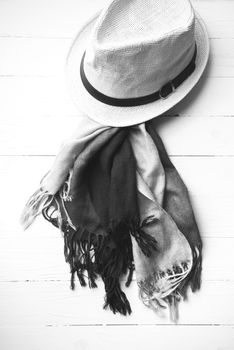 hat and blue scarf on white table black and white color