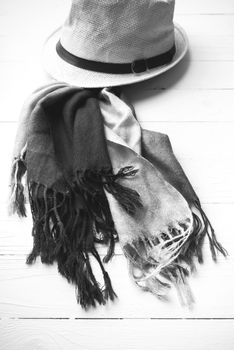 hat and blue scarf on white table black and white color