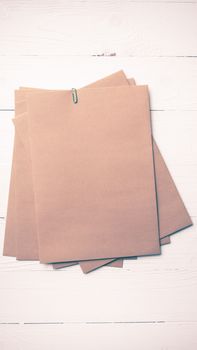brown paper with green paper clip over white table vintage style