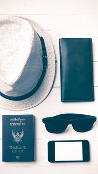 hat sunglasses smart phone and passport over white table vintage style