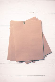 brown paper with green paper clip over white table vintage style