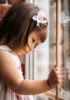 portrait of a little girl looking out the window