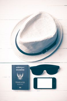 hat sunglasses smart phone and passport over white table vintage style